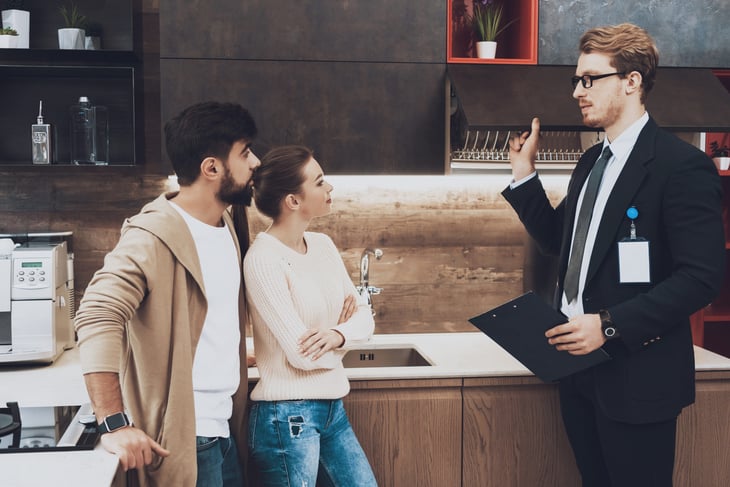 Skeptical couple talking to a salesman about renovating their kitchen