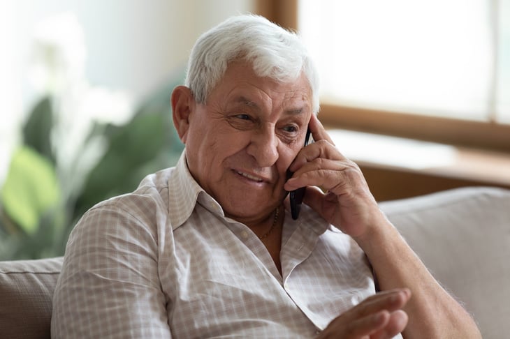 Senior happily talking on smartphone or cellphone