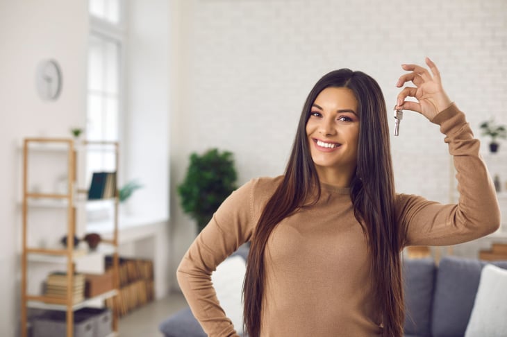 woman holding key in apartment new home