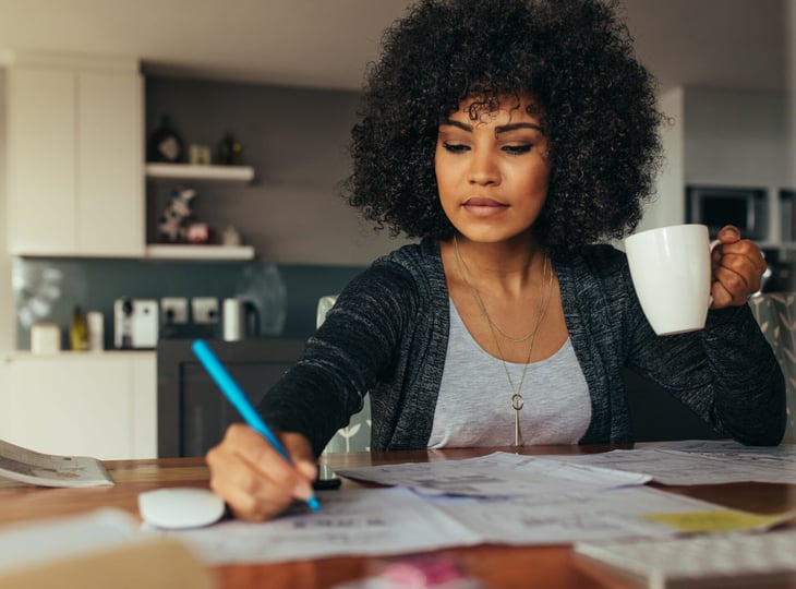 Woman drinking coffee while working from home