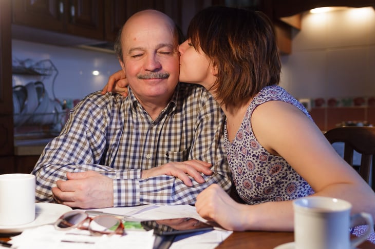 Young woman kissing retiree senior Dad.