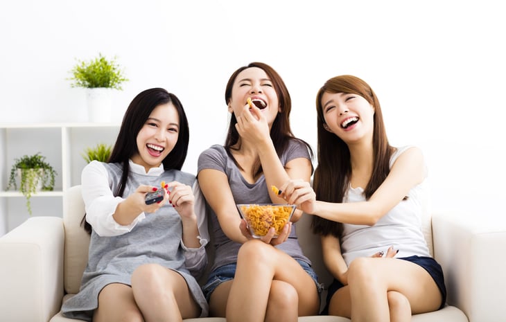Three women friends watching TV