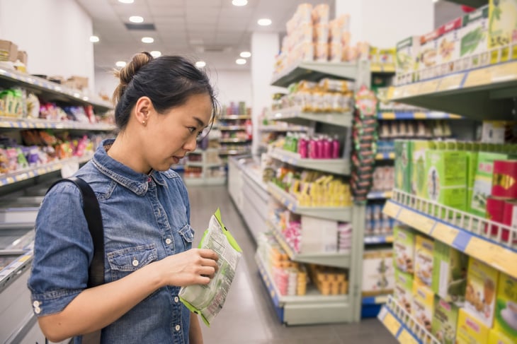 Woman considering options in a dollar store or grocery store