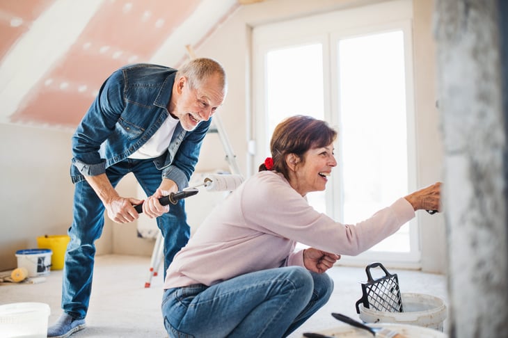 Senior couple painting the walls of their home