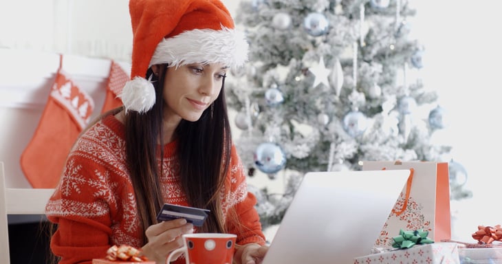 Happy woman using credit card for holiday shopping