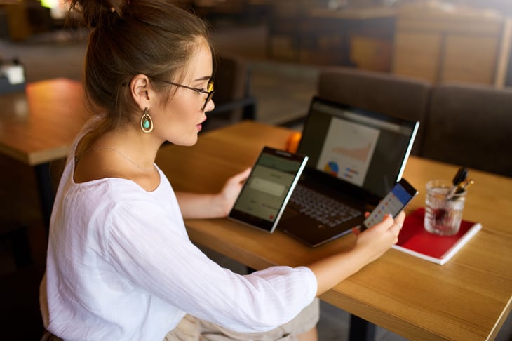 Young woman freelancer or businesswoman using phone tablet and laptop