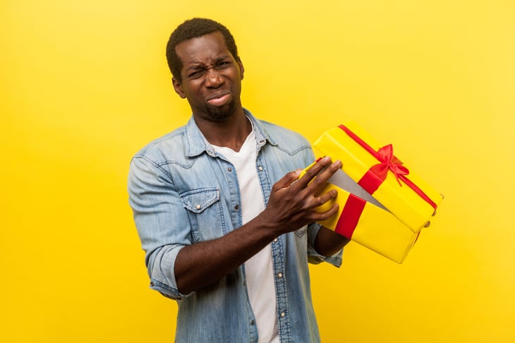 Upset man cringes at a bad gift