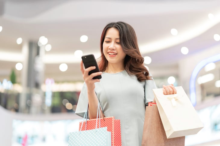 Woman looking at her phone while shopping at a mall