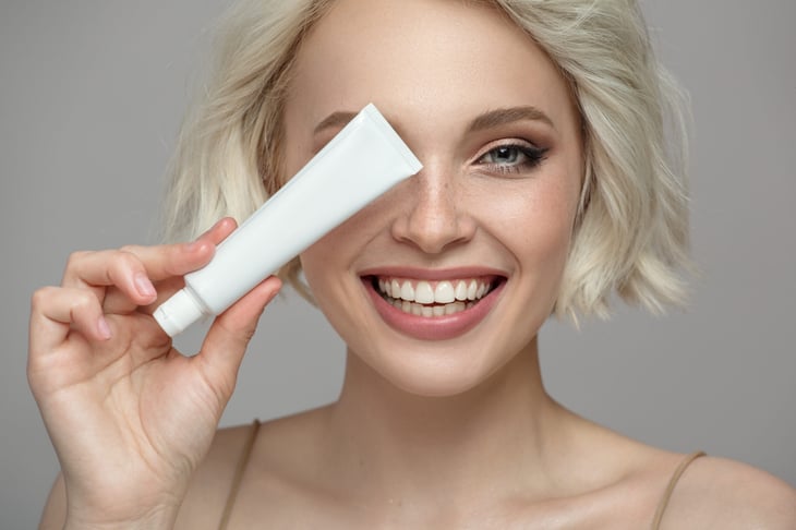 Woman holding a tube of toothpaste