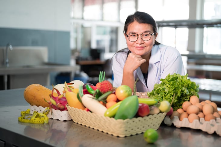A woman in front of a basket of fresh produce
