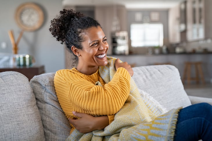 Happy woman relaxing on her sofa