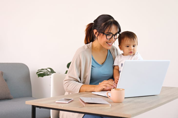 A young mother working remotely with her child