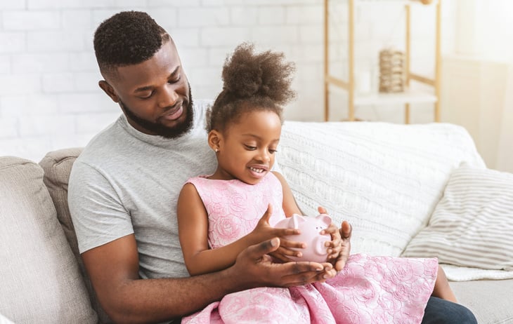 Father and daughter with piggy bank