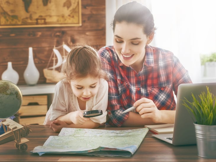 Mother and daughter planning travel and vacation on a map