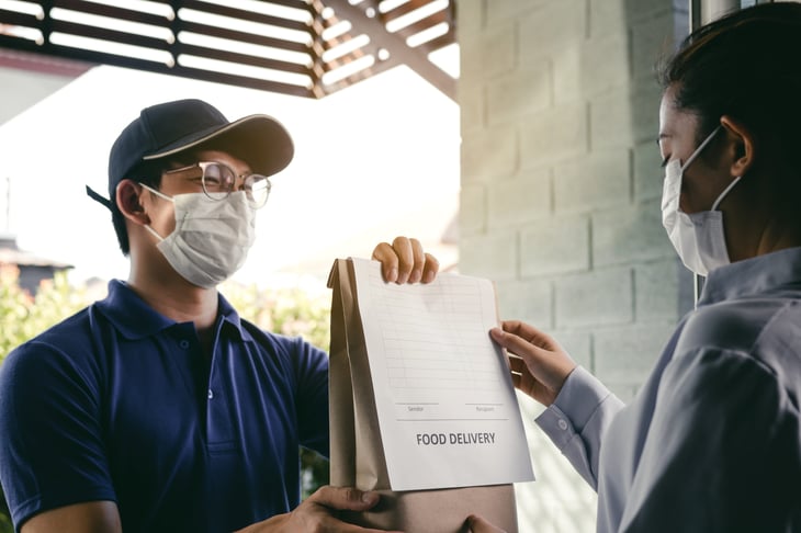 Making a food delivery while wearing a mask