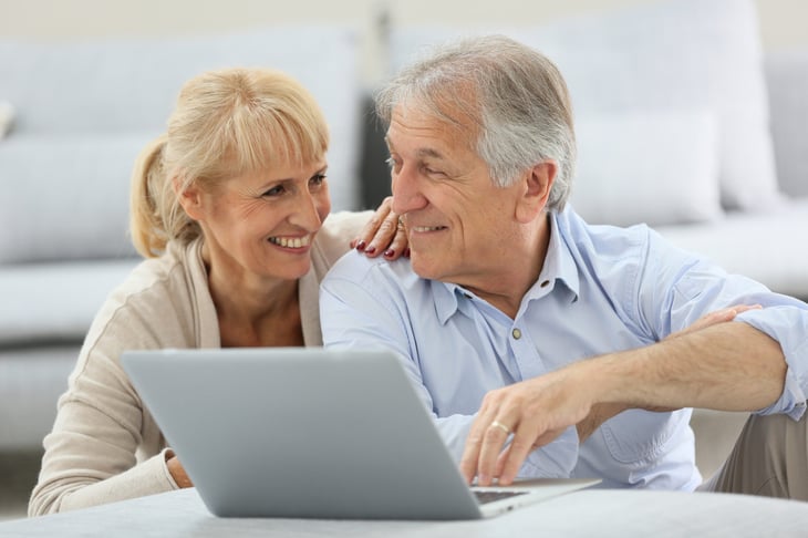 Happy senior couple use a laptop