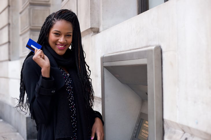 Woman using a debit card at an ATM