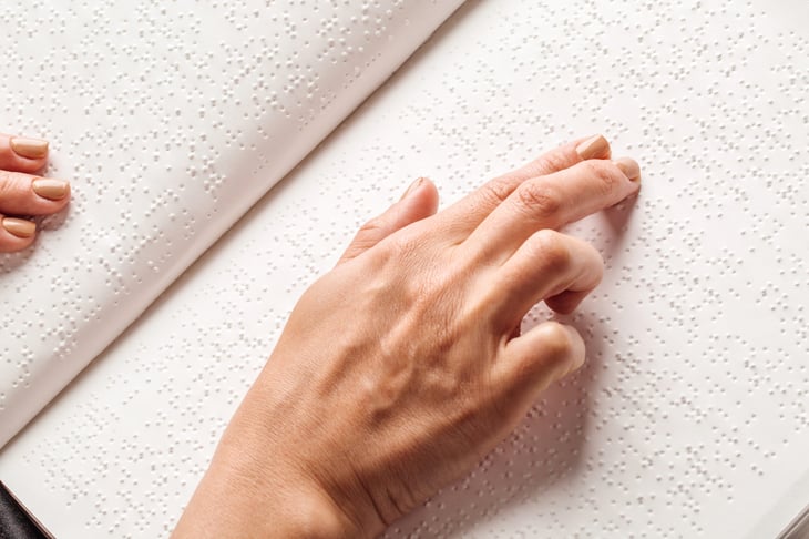 Blind person reading a book in braille