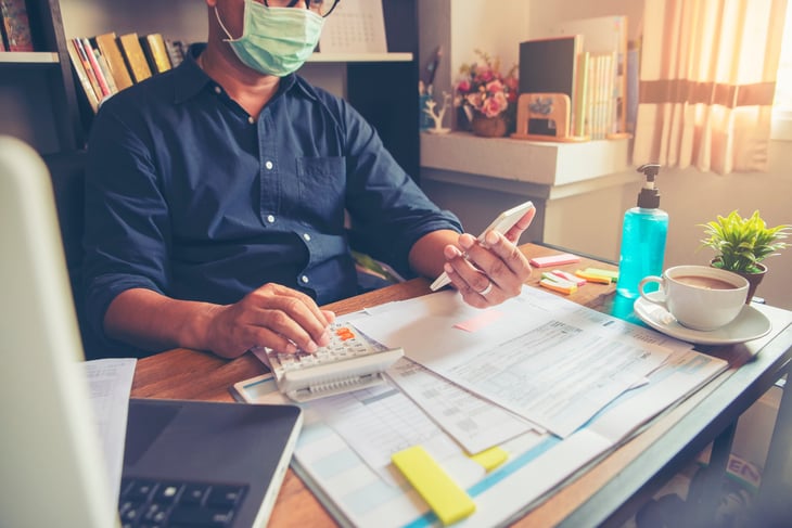 Man in a mask doing his taxes