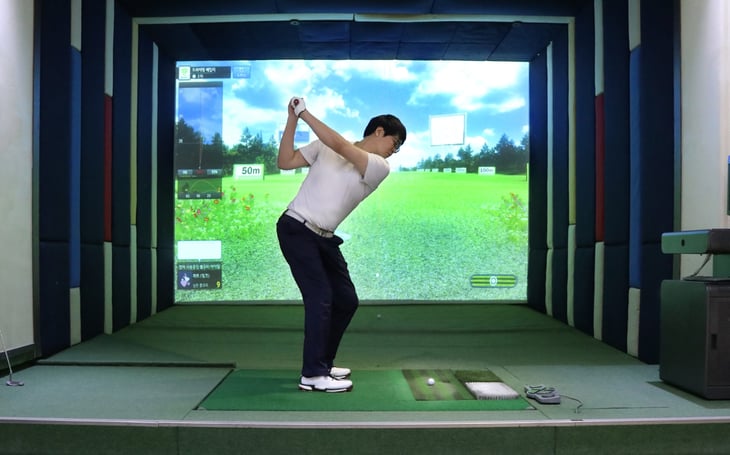 Man playing golf in a simulator