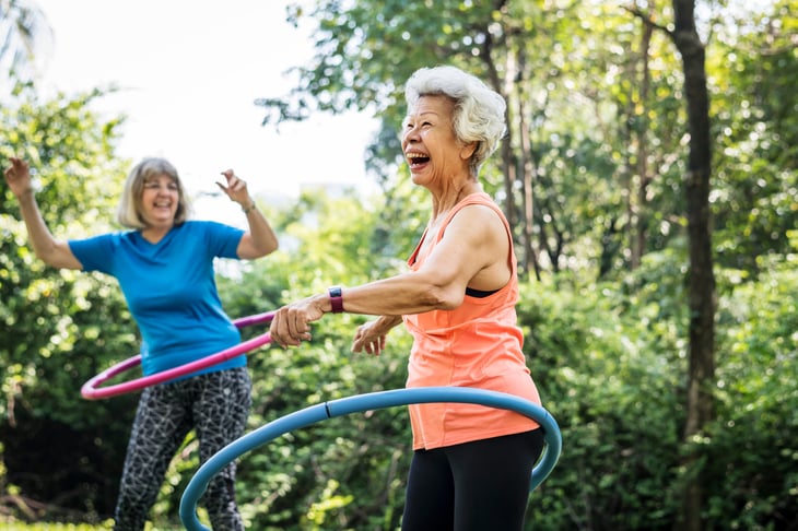 Happy seniors exercising with hula hoops