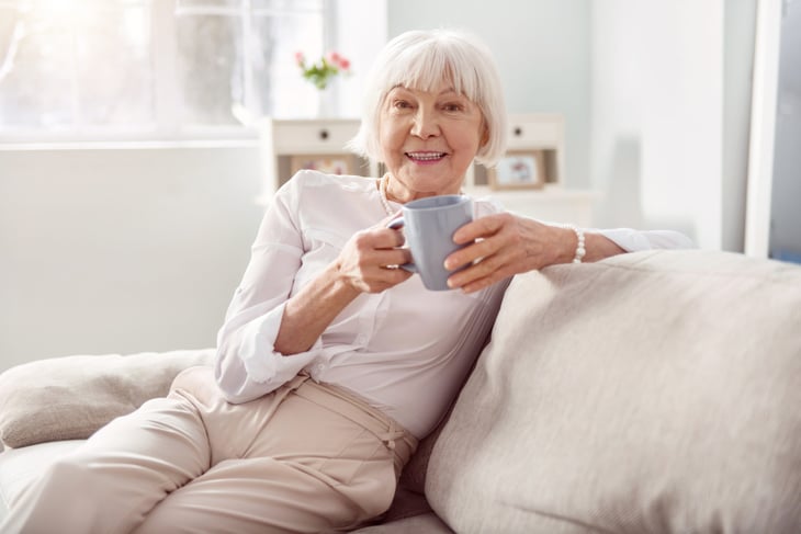 Senior drinking coffee at home