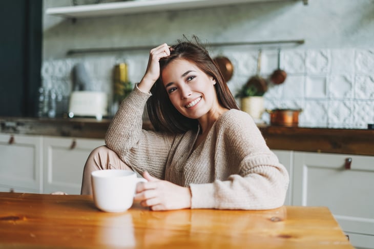 Happy woman drinking coffee at home