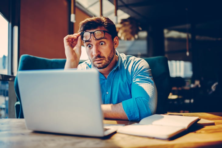Shocked man looking at his laptop