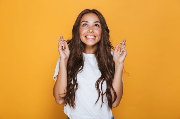 Young woman crossing her fingers and feeling lucky