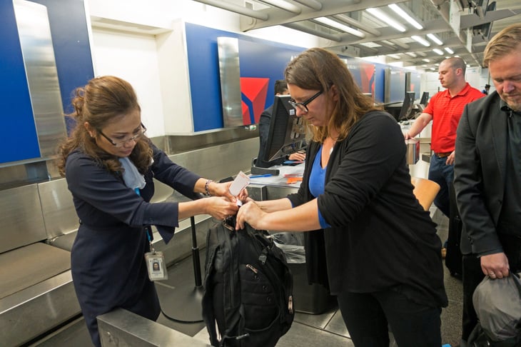 Woman checks tickets and bags at an airport