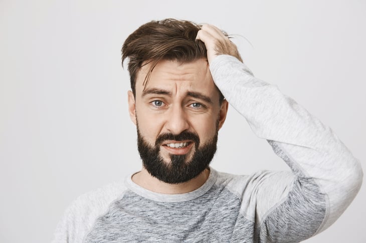 Confused man scratching his head