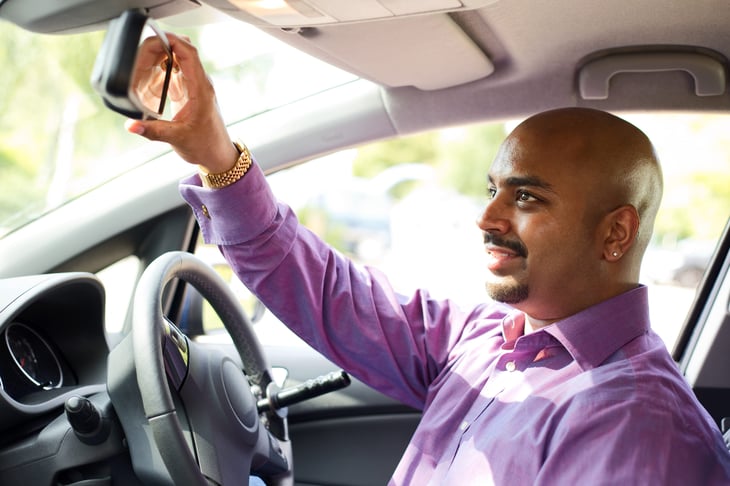 Driver adjusting his mirror