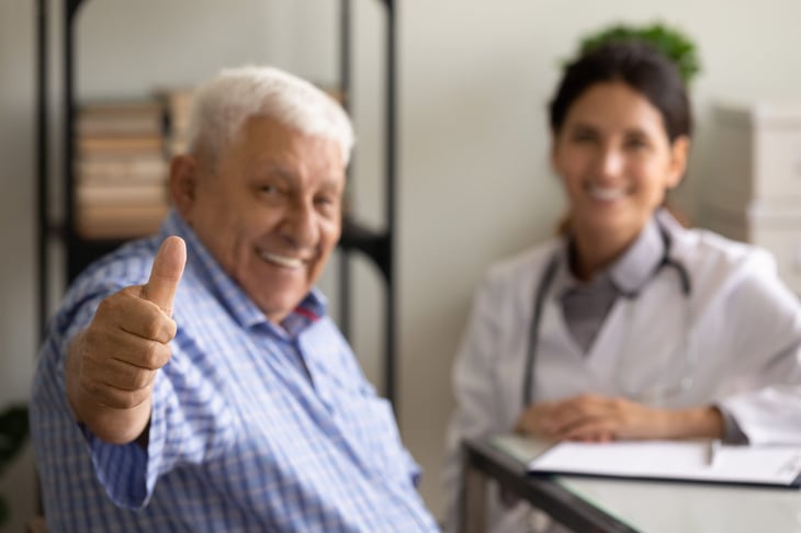 Senior patient gives thumbs up in doctor's office