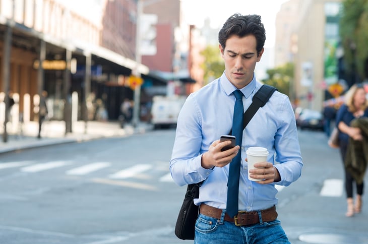Man walking and looking at his phone
