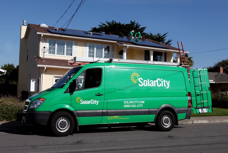 SolarCity technicians installing solar panels on a home
