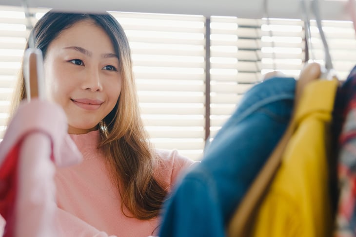 Woman looking at clothes in her closet