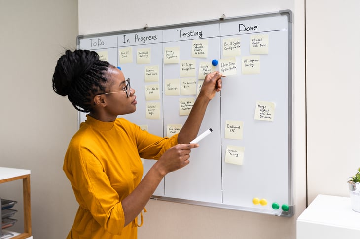 woman using stick notes on a whiteboard