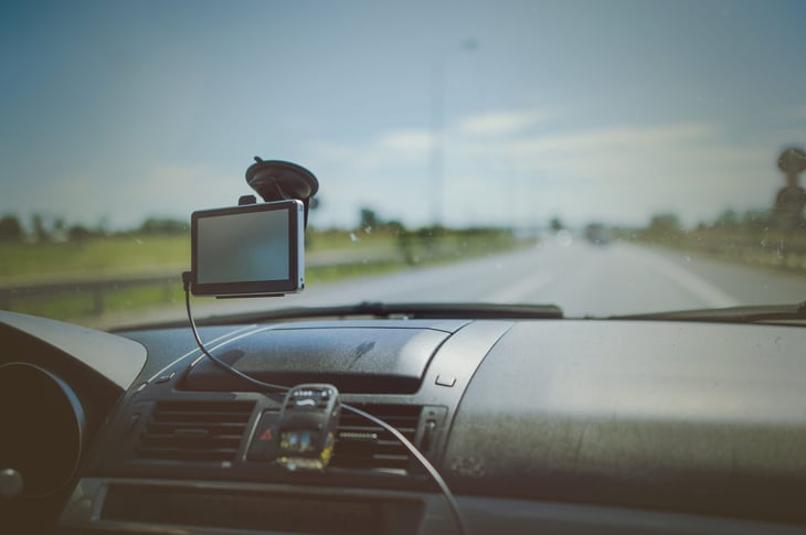 Smartphone mounted on a car's windshield while on a highway.