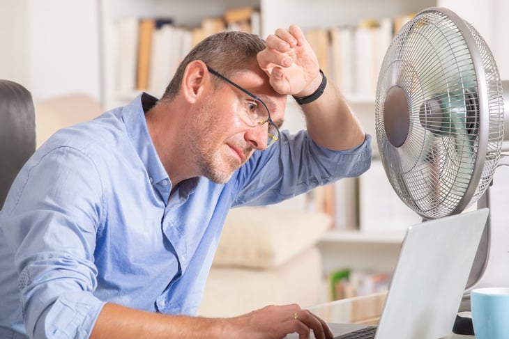 Man in front of fan on computer