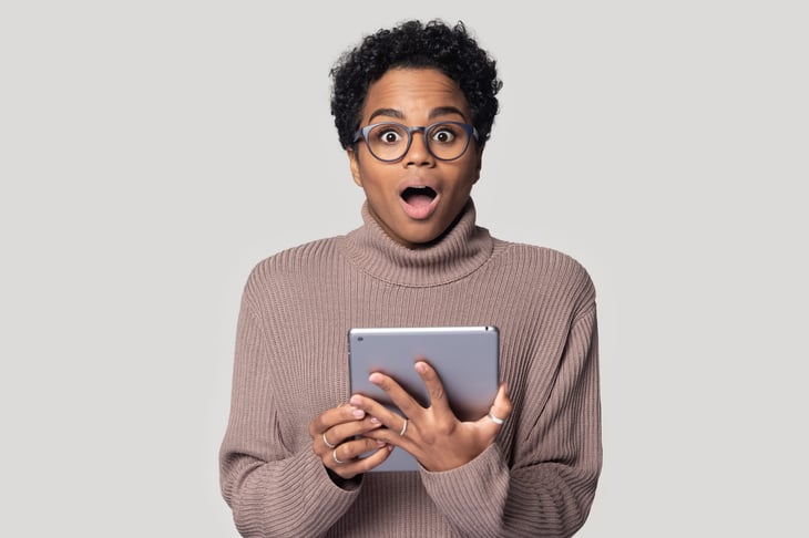 Suprised woman looking at her tablet