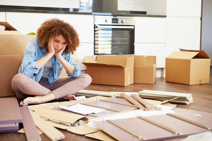 Unhappy woman assembling furniture