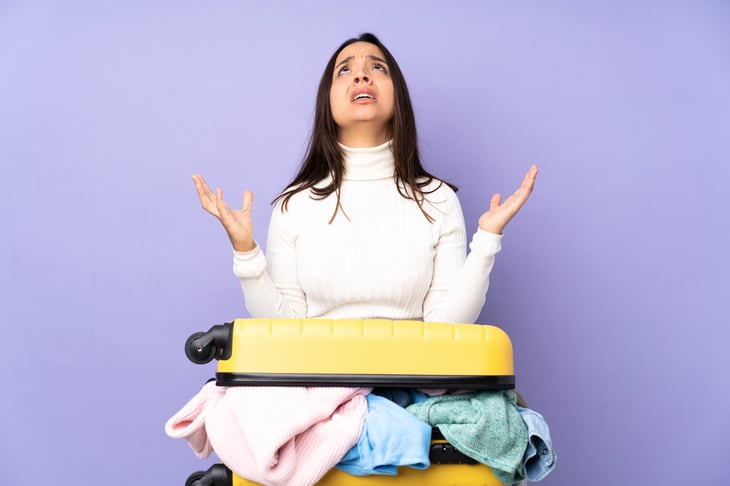 Unhappy woman can't close luggage