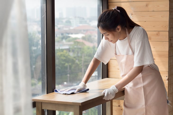 Woman wearing gloves to clean her home