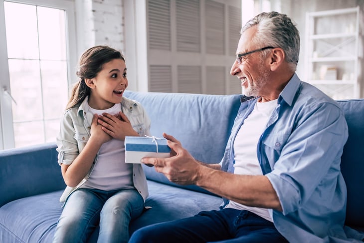 Grandfather giving a gift to his surprised grandchild