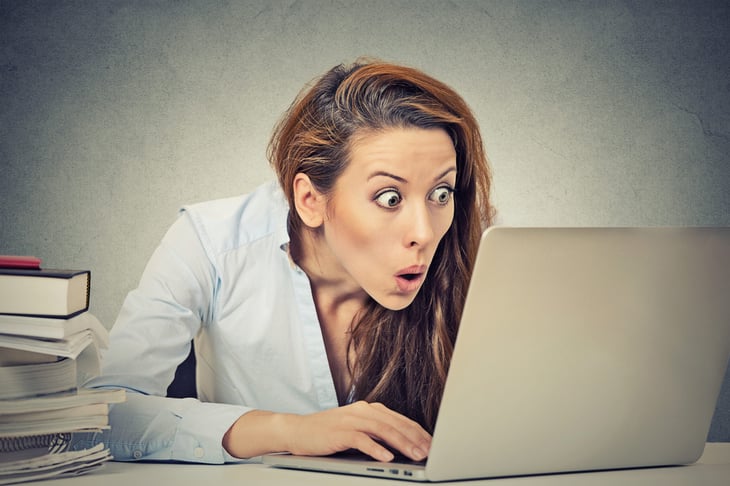 Shocked woman at her laptop computer