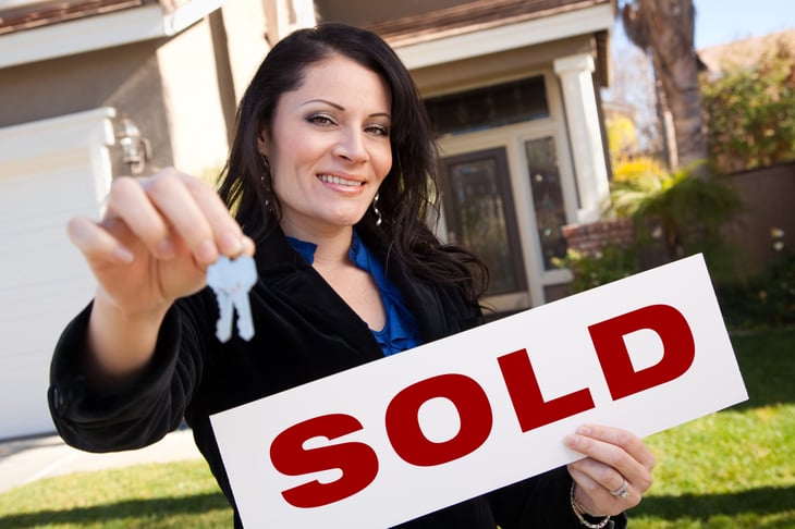 Real estate agent with sold sign