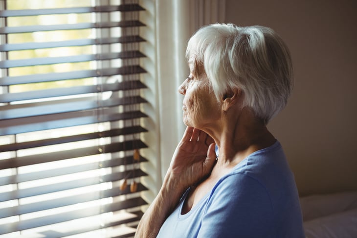 Sad senior looking out a window