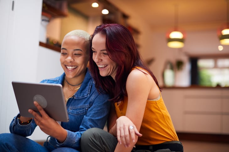 Happy couple using a tablet computer at home