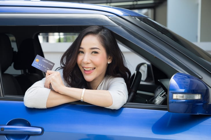 Woman in a car with a credit card