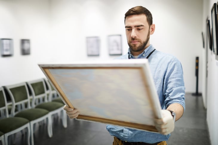 man looking at artwork